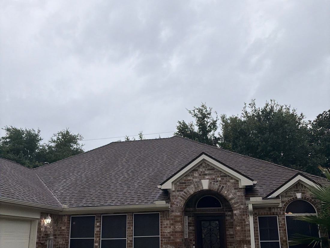 Completed architectural shingle roof on a brick home in Cypress